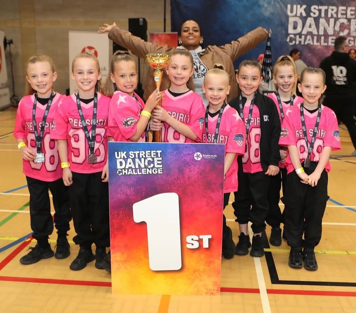 D2E Rebel Spirit squad in pink jerseys celebrating 1st place at the UK Street Dance Challenge